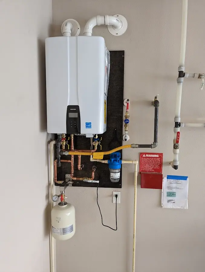 Professional plumber installing copper piping in a Grand Rapids home
